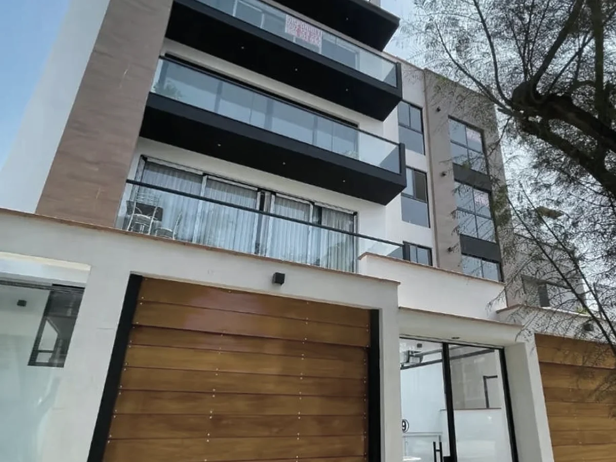 Edificio Neptuno terminado: balcones de vidrio y portones de madera